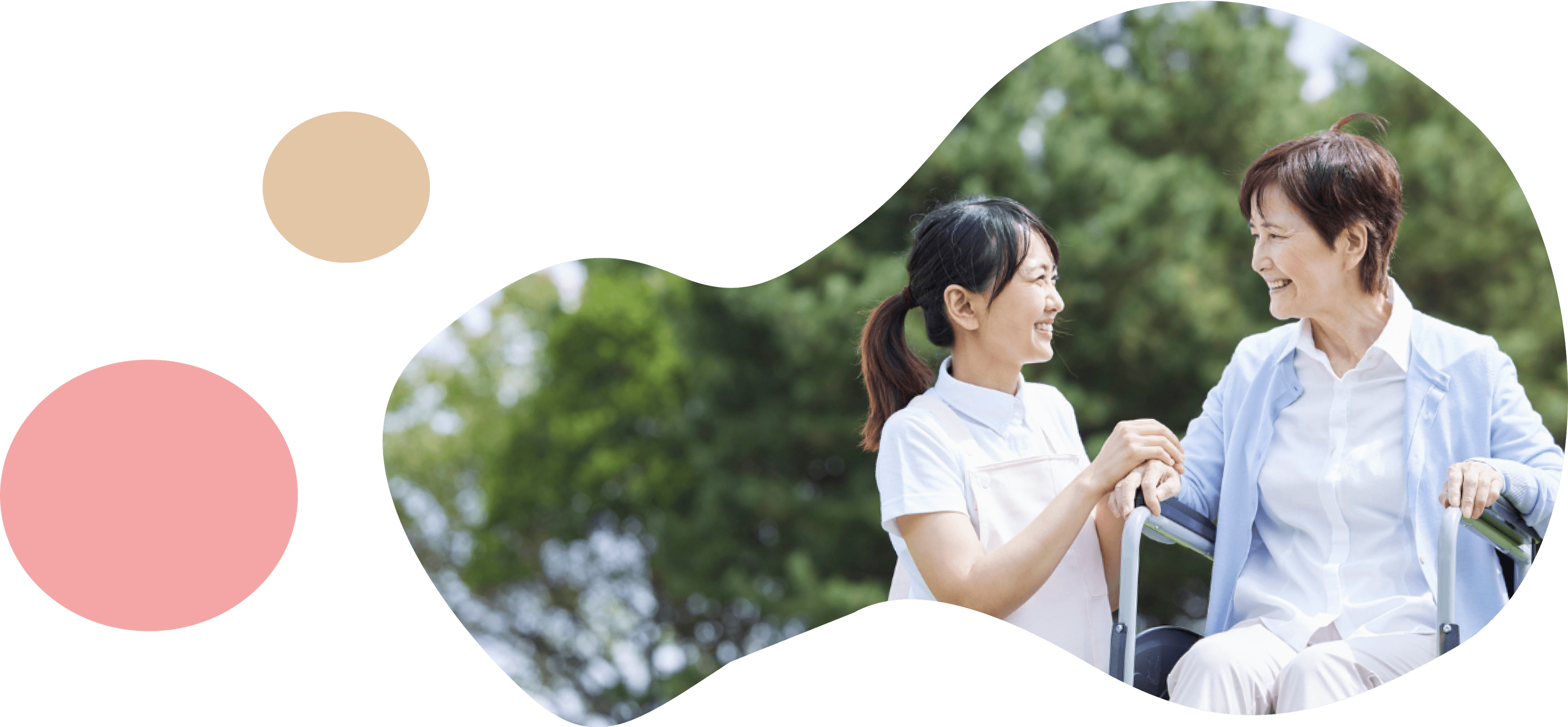 車椅子の女性を介助する看護職員